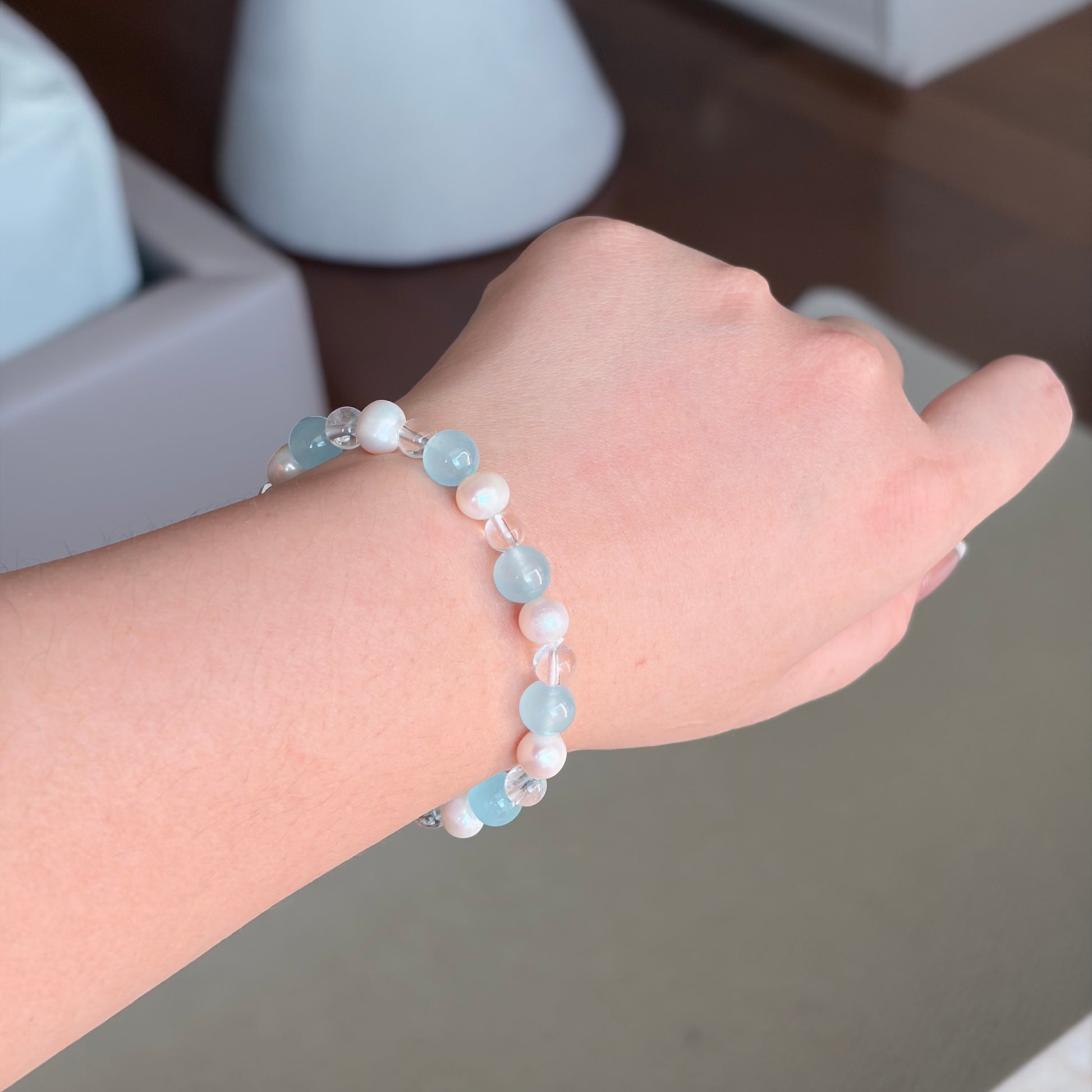 Aquamarine Clear Quartz Freshwater Pearl Ocean Flow Bracelet worn on the wrist in soft natural light, a Water element bracelet with aquamarine, clear quartz, and freshwater pearls.