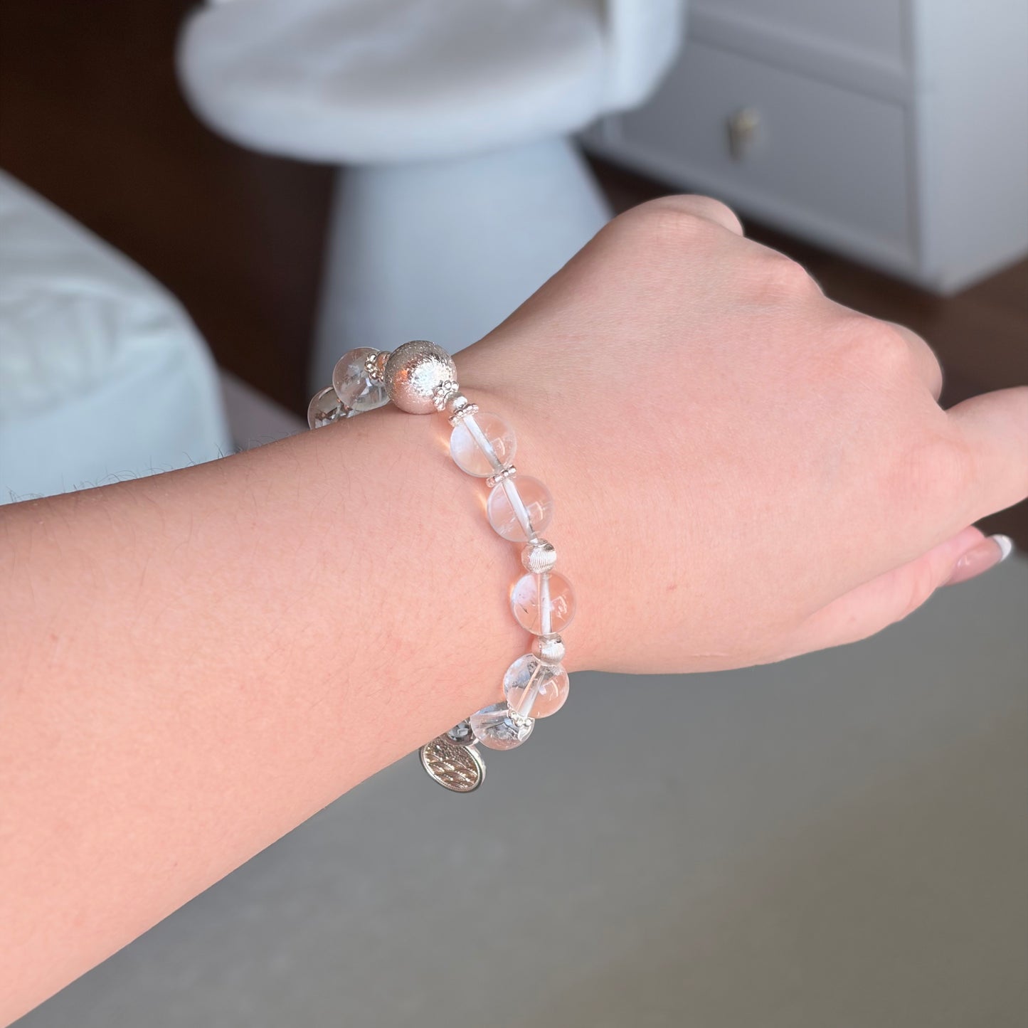 Clear Quartz Moonlit Clarity Bracelet worn on the wrist in soft natural light, a Metal element clear quartz bracelet with silver-toned accents and a moonlit polished finish.