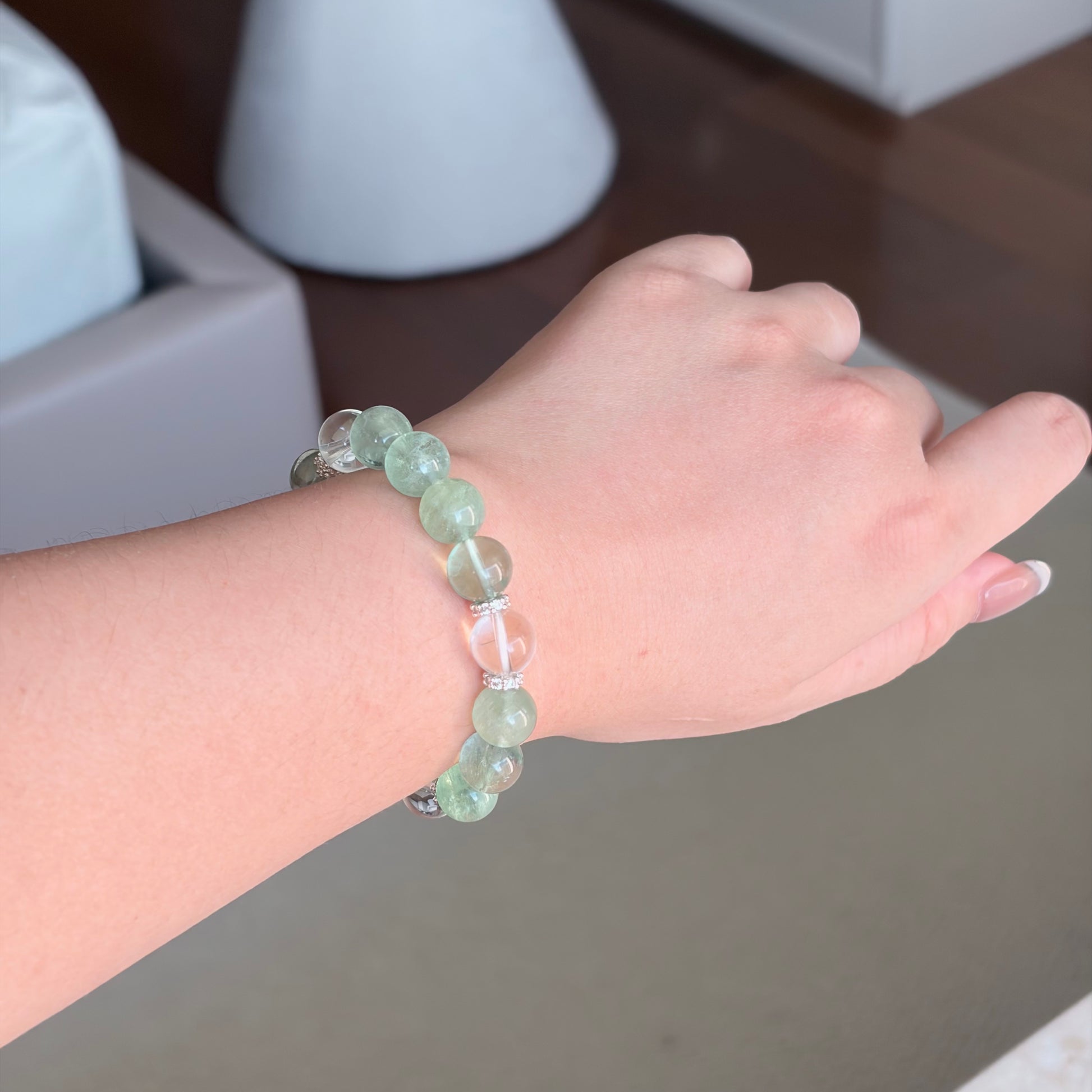 Green Fluorite Clear Quartz Spring Grove Bracelet worn on the wrist, a Wood element bracelet with green fluorite, clear quartz, and silver-toned spacer details.