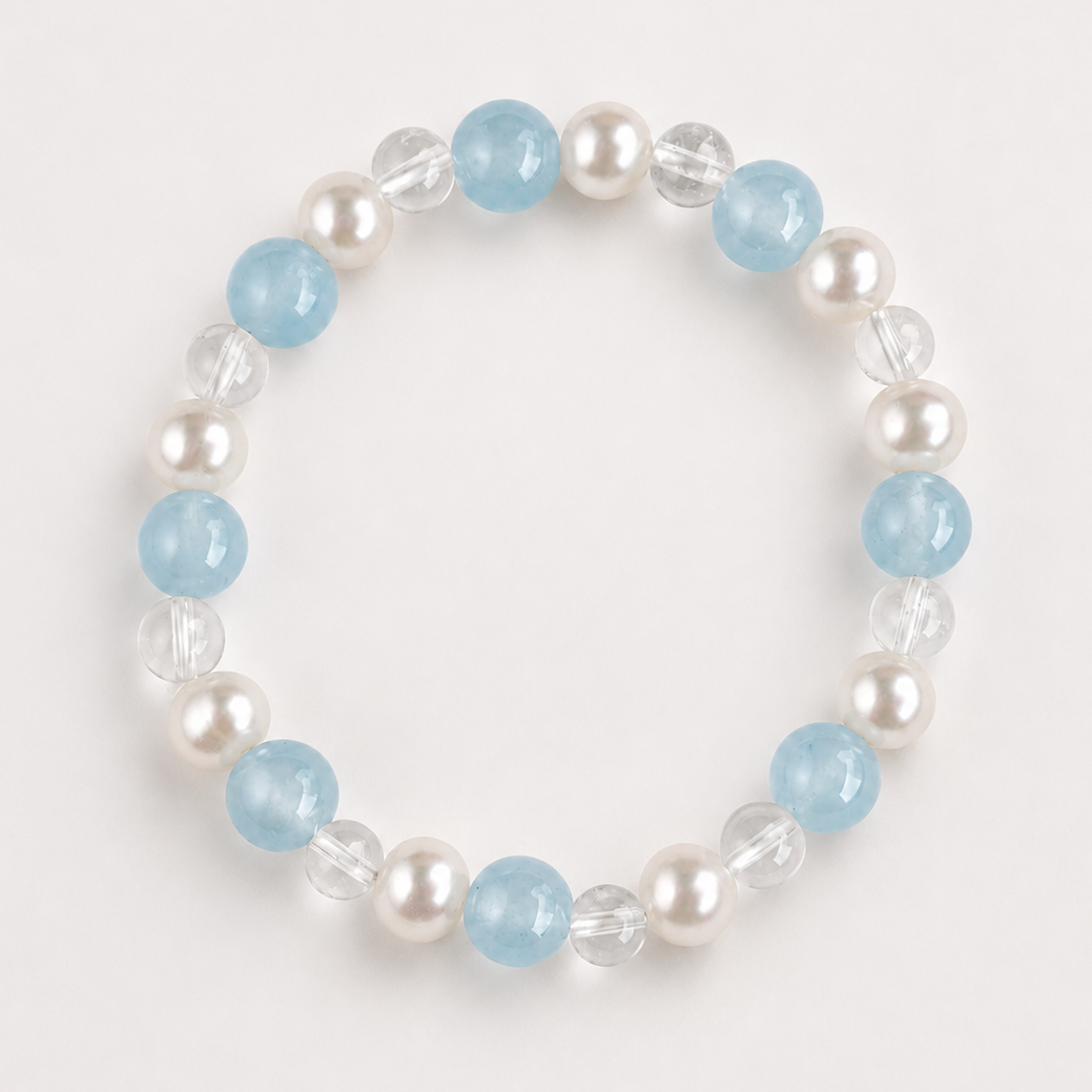 Aquamarine, clear quartz, and freshwater pearl Water bracelet on a soft light gray background.