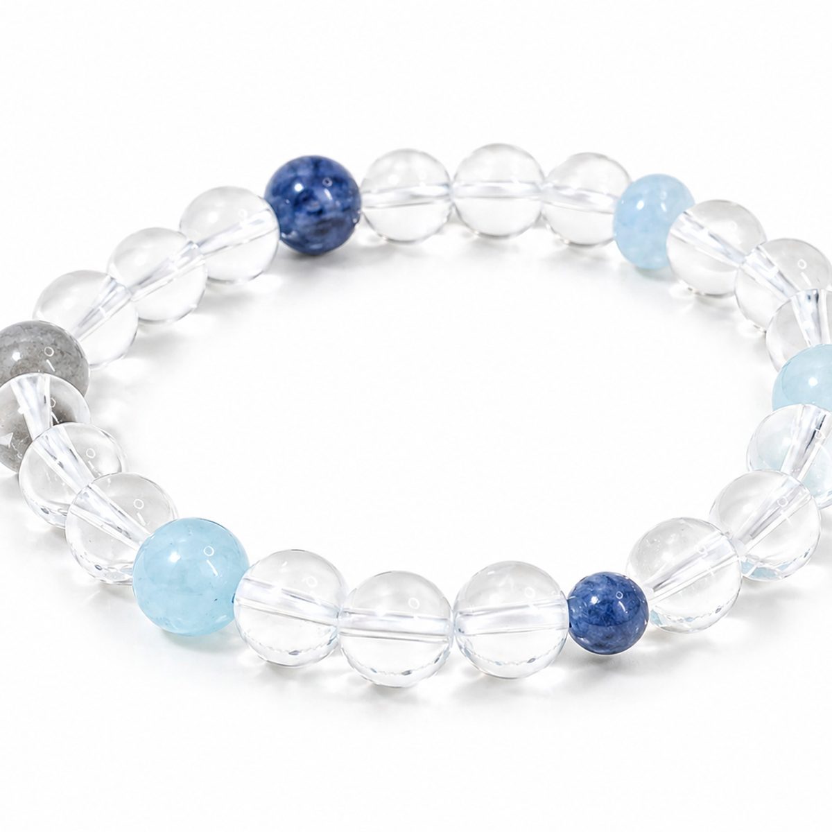 Blue kyanite moonstone and clear quartz bracelet on white background by Veyra Grove