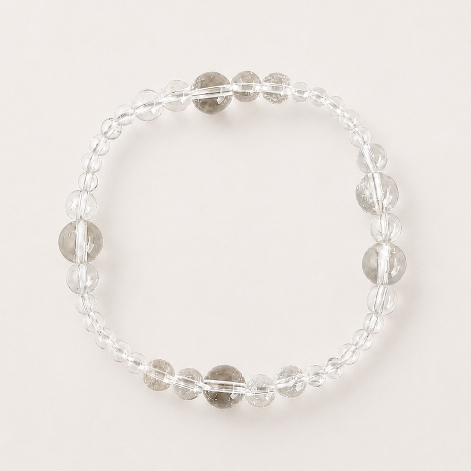 Clear quartz mixed-bead bracelet on a soft light gray background.