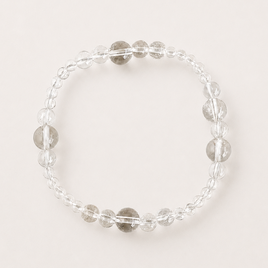 Clear quartz mixed-bead bracelet on a soft light gray background.