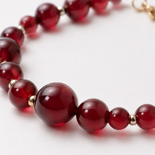 Close-up of Red Agate Ember Line Bracelet showing glossy red agate beads and gold-tone details.