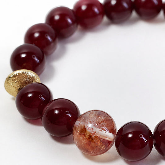 Close-up of glossy red agate beads and gold-toned accent on Veyra Grove bracelet
